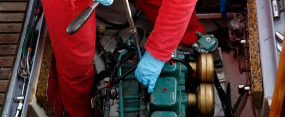 a service engineer fixing the engine of a vessel