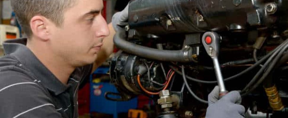 a young man mechanic repairing motor boats and other