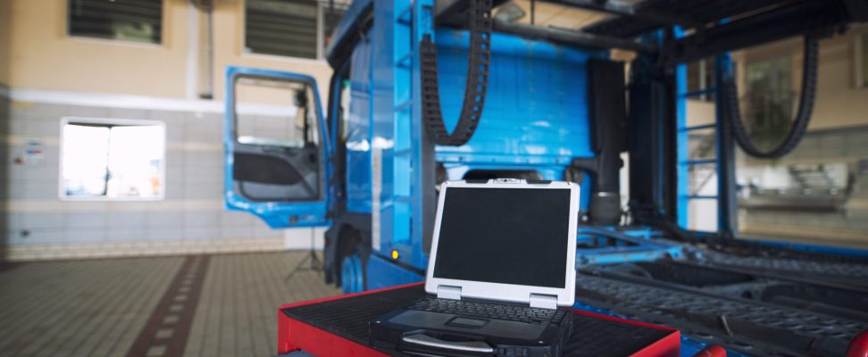 truck workshop interior with tools cart and laptop computer diagnostics tool for servicing truck vehicles.